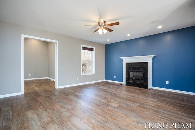 unfurnished living room with hardwood / wood-style floors, ceiling fan, and a fireplace