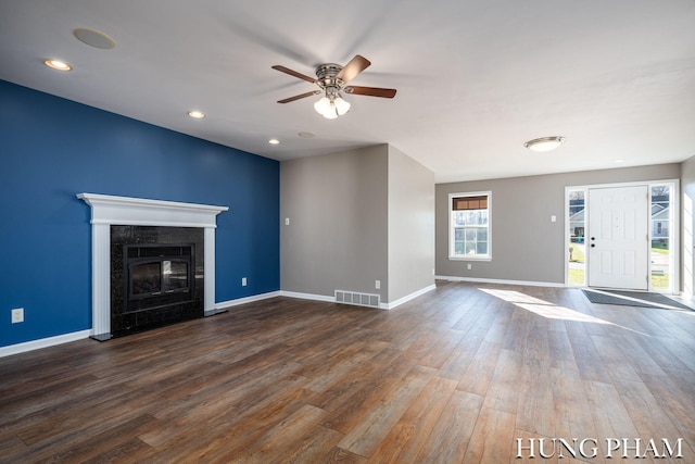 unfurnished living room with a fireplace, dark hardwood / wood-style floors, and ceiling fan