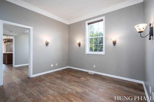 spare room with dark wood-type flooring and crown molding