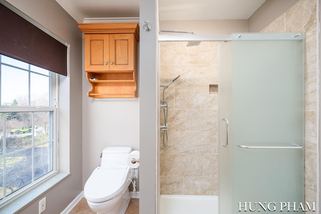 bathroom featuring a shower with shower door, plenty of natural light, toilet, and tile patterned floors