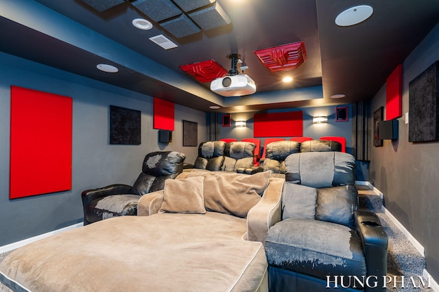 carpeted cinema room featuring a tray ceiling