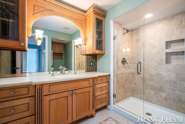 bathroom featuring walk in shower, vanity, and tile patterned floors