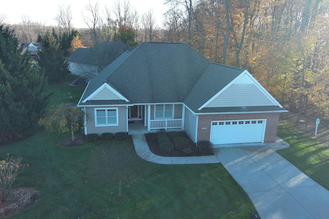 view of front of home featuring a front lawn, covered porch, and a garage