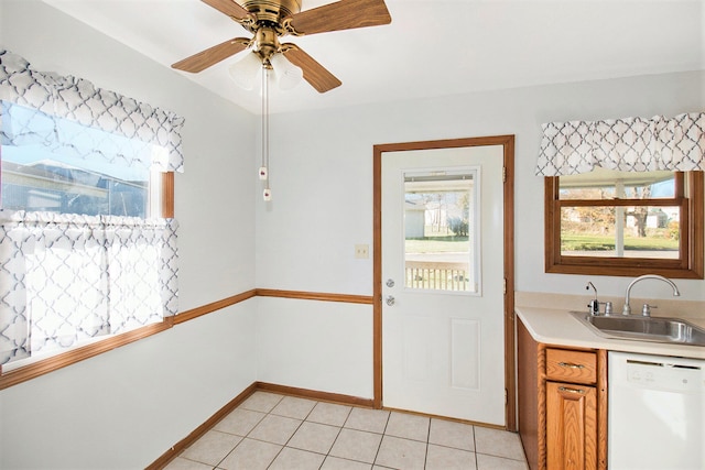 kitchen featuring light tile patterned flooring, sink, a healthy amount of sunlight, and white dishwasher