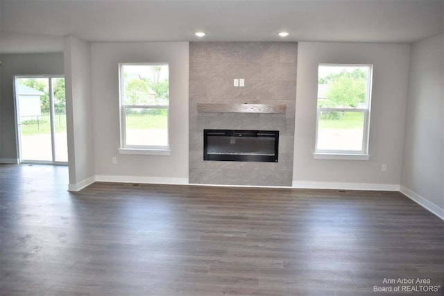 unfurnished living room with dark wood-type flooring and a fireplace