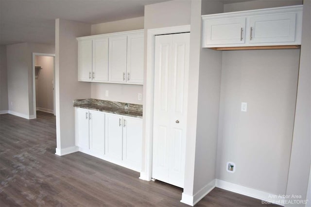 kitchen with white cabinetry, dark hardwood / wood-style floors, and dark stone countertops