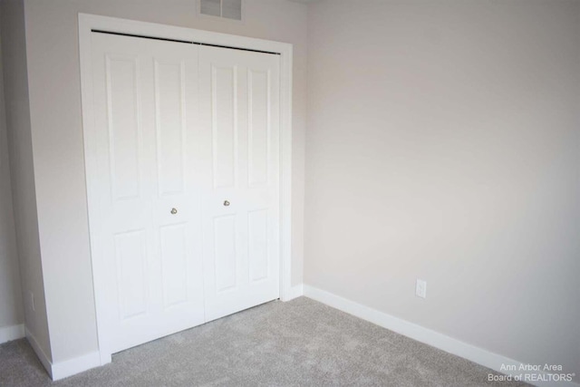 unfurnished bedroom with carpet floors and a closet