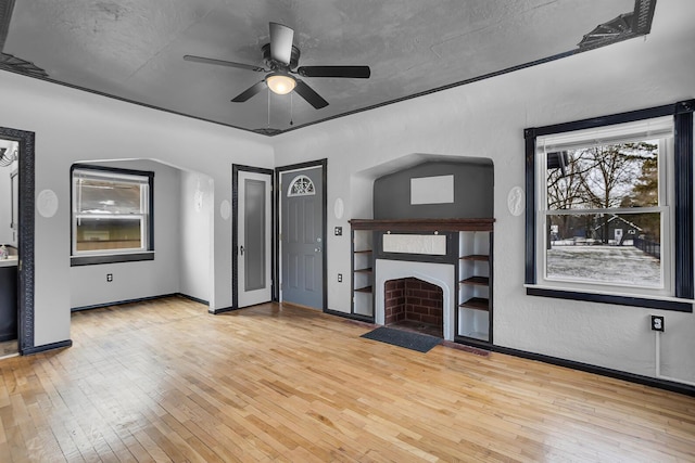 unfurnished living room featuring ceiling fan, a textured ceiling, and light wood-type flooring