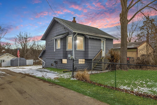 view of front of property with a shed and a yard