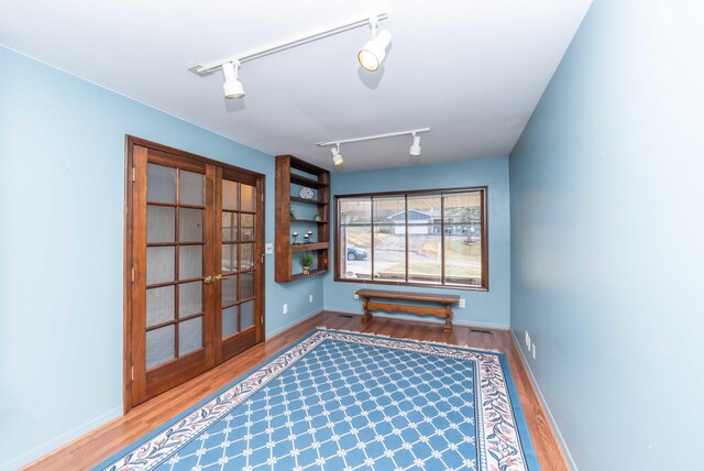 interior space with track lighting, hardwood / wood-style flooring, and french doors