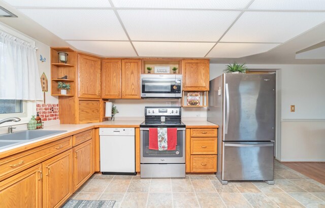 kitchen featuring a paneled ceiling, appliances with stainless steel finishes, and sink