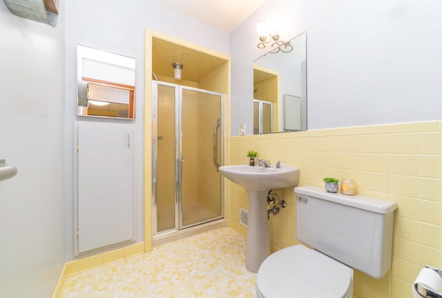 bathroom with walk in shower, tile walls, and toilet