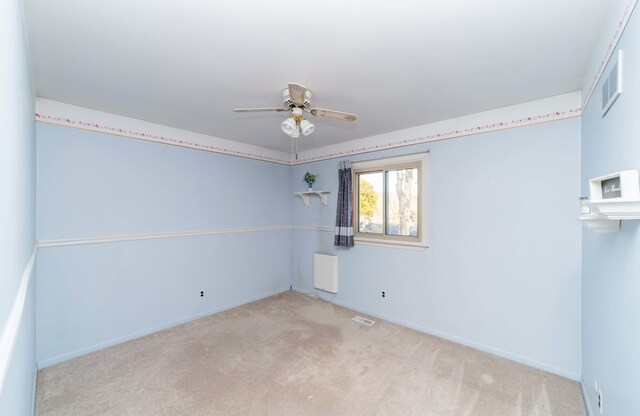 carpeted spare room featuring ceiling fan