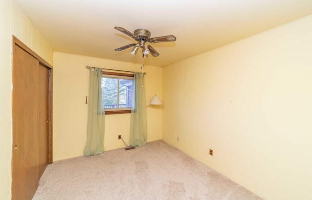 unfurnished bedroom featuring a closet, carpet flooring, and ceiling fan