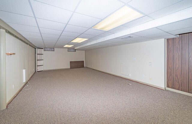 basement featuring a drop ceiling and carpet floors