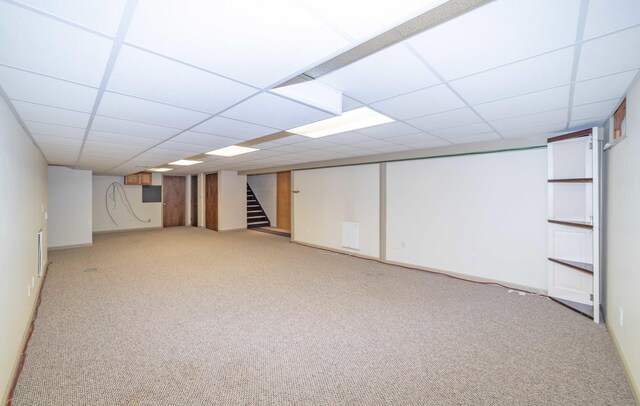 basement featuring a drop ceiling and carpet floors