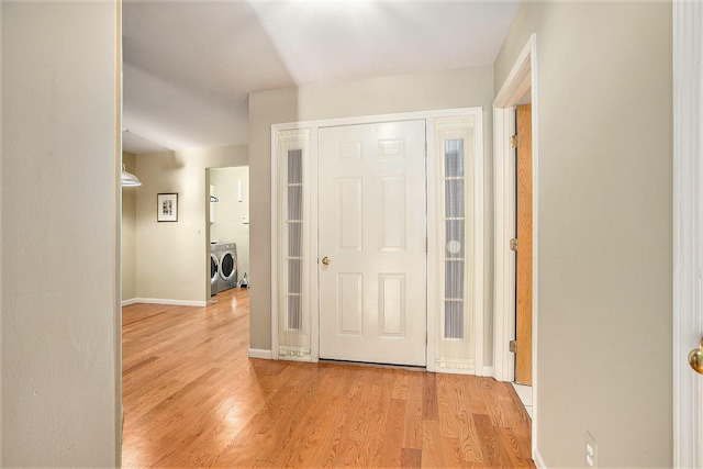 foyer entrance featuring light hardwood / wood-style floors and separate washer and dryer