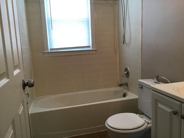 full bathroom with vanity, tiled shower / bath combo, and toilet