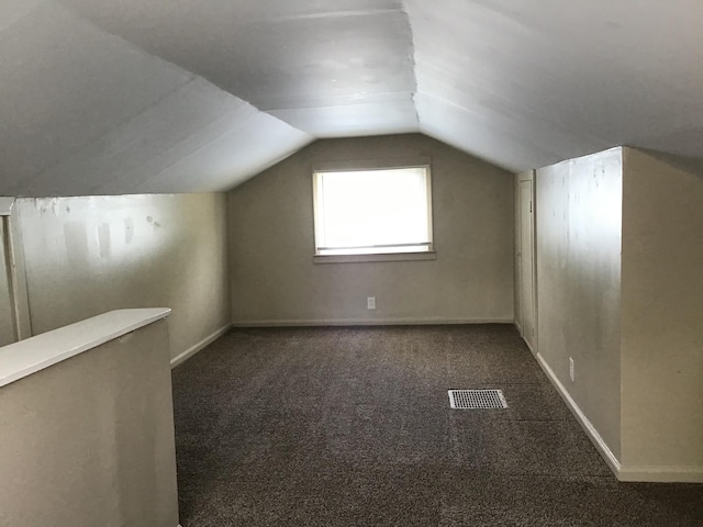 bonus room featuring dark colored carpet and lofted ceiling