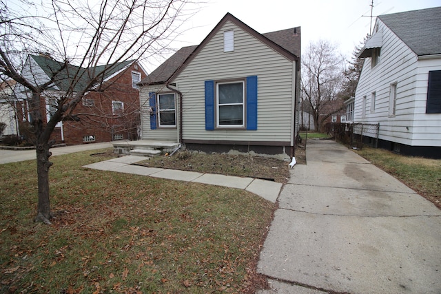 bungalow-style home with a front yard