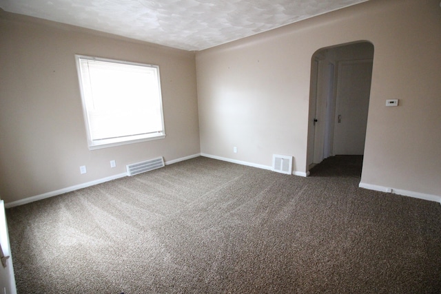 carpeted empty room featuring a textured ceiling