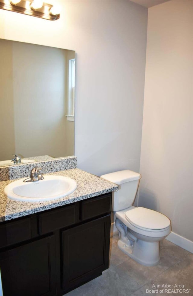 bathroom featuring tile patterned floors, vanity, and toilet