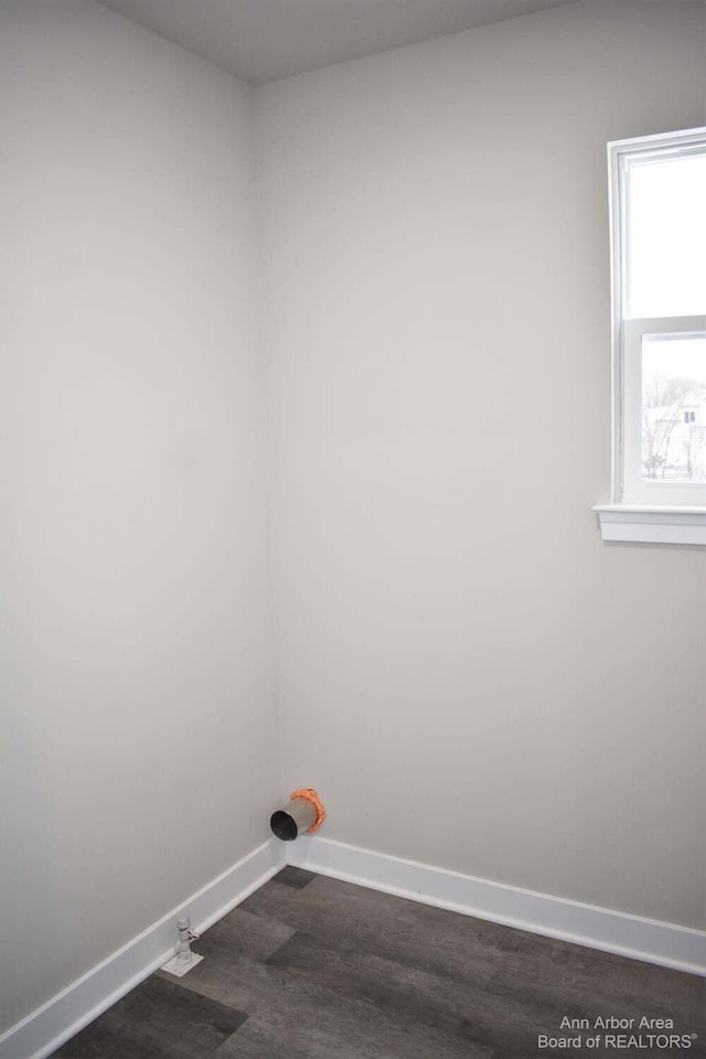 clothes washing area with dark wood-type flooring