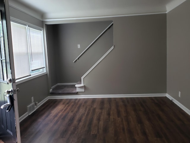 spare room featuring crown molding and dark hardwood / wood-style flooring