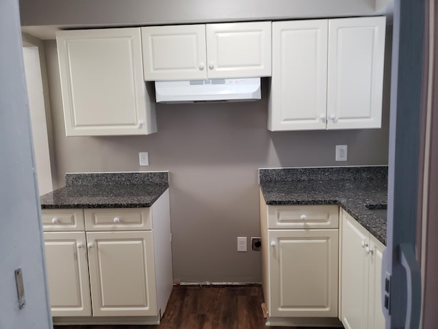 kitchen featuring extractor fan, white cabinets, dark hardwood / wood-style floors, and dark stone countertops