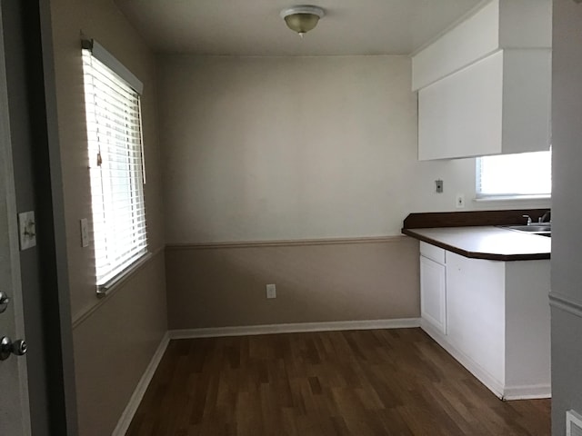 kitchen featuring dark wood-type flooring, sink, and white cabinets