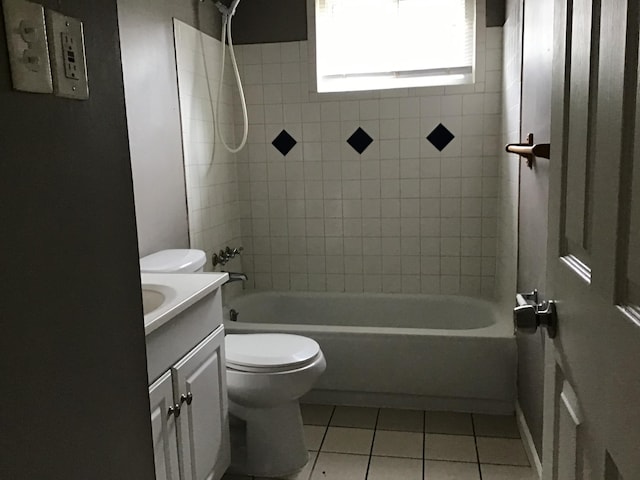 full bathroom featuring toilet, tiled shower / bath combo, vanity, and tile patterned flooring