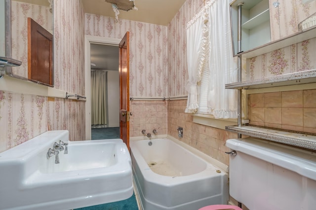 bathroom featuring tile walls, a washtub, and sink