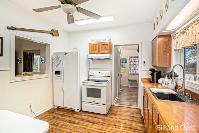 kitchen with ceiling fan, vaulted ceiling, sink, white appliances, and dark wood-type flooring