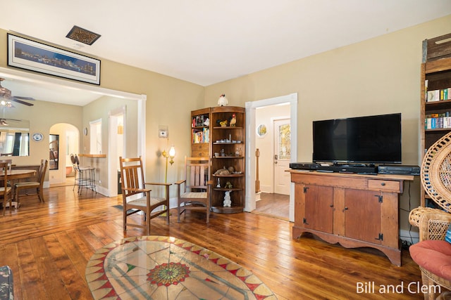 living room with ceiling fan and dark hardwood / wood-style flooring