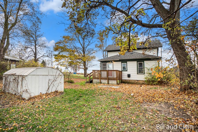 exterior space featuring a lawn, a storage unit, and a wooden deck