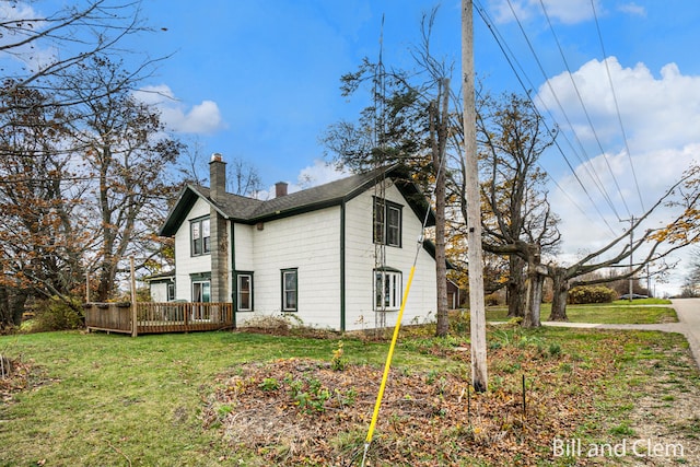 view of side of property featuring a deck and a lawn