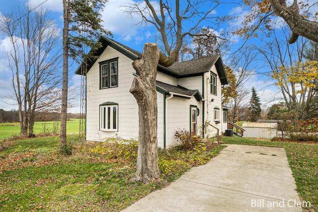 view of home's exterior with central AC unit and a lawn