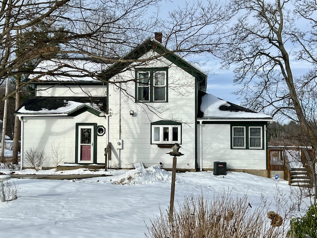 snow covered back of property featuring cooling unit