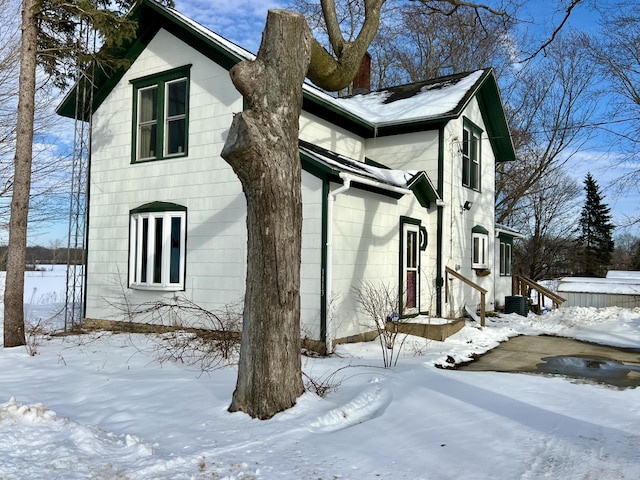 view of snow covered exterior featuring central air condition unit