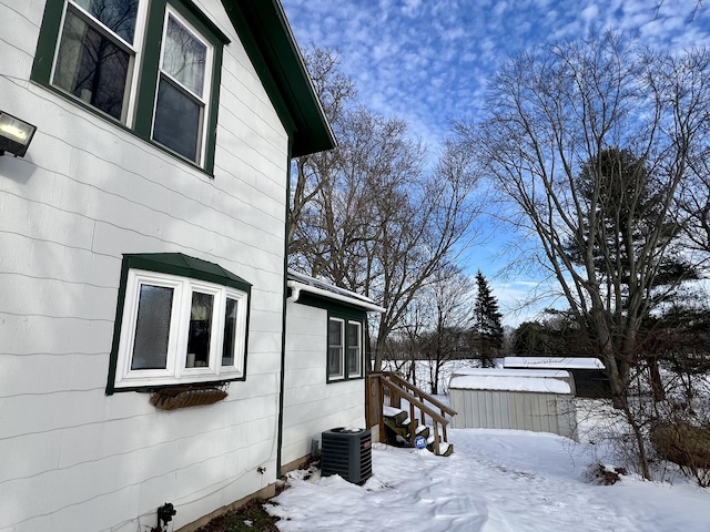 view of snow covered exterior with central AC