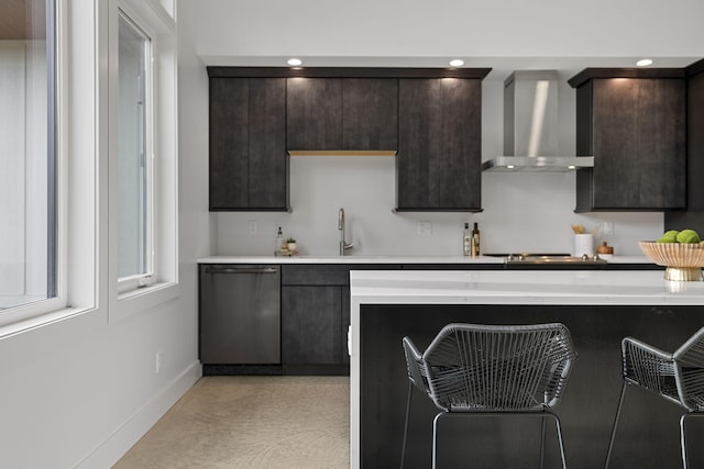 kitchen with wall chimney range hood, sink, dark brown cabinetry, and stainless steel appliances