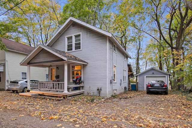 view of front of house featuring a garage, an outdoor structure, and covered porch