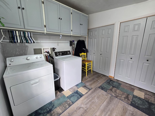 washroom with cabinets, dark hardwood / wood-style floors, and washing machine and clothes dryer