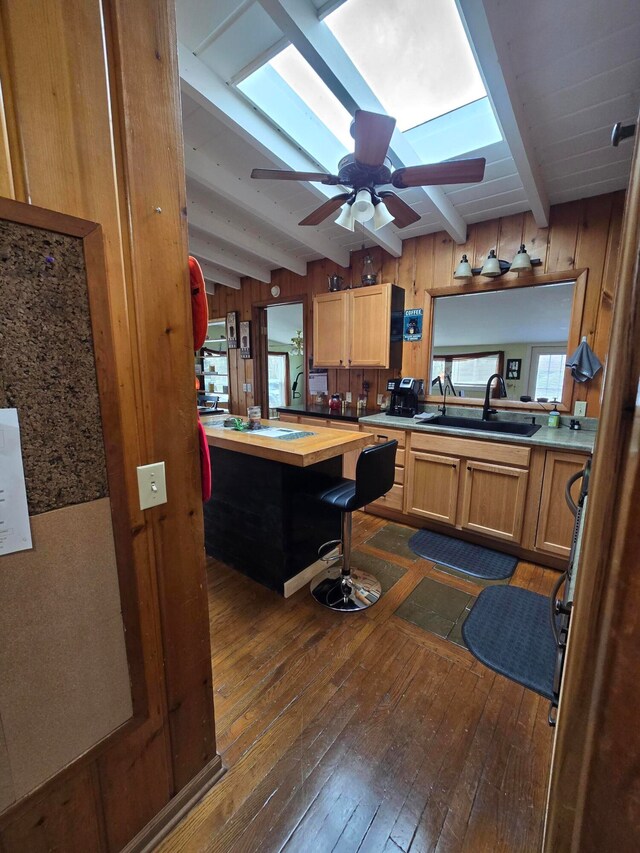 kitchen with butcher block countertops, wood walls, and beamed ceiling