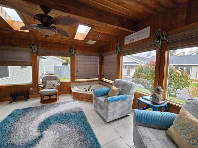 sunroom / solarium with a skylight, wooden ceiling, and ceiling fan