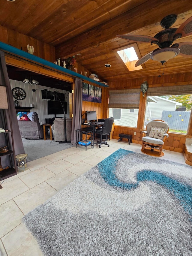 interior space featuring wood walls, ceiling fan, lofted ceiling with skylight, and wooden ceiling