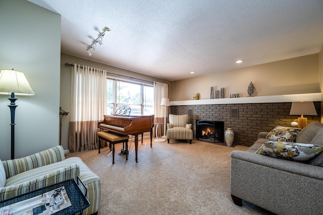 living room featuring a fireplace, a textured ceiling, and track lighting