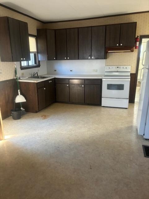 kitchen with white appliances, dark brown cabinets, and sink