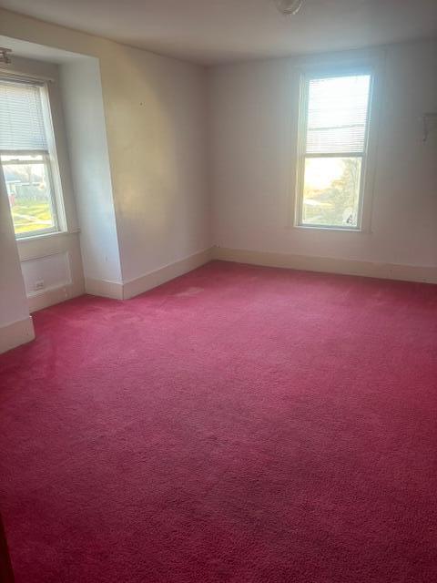 carpeted spare room featuring a healthy amount of sunlight