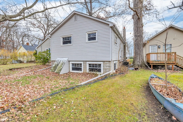 back of property featuring a yard and a wooden deck